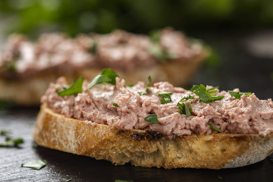 Liverwurst Sandwich with chopped parsley on a dark slate