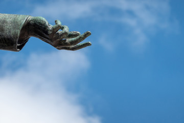 Hand of a bronze statue, open to show the will to peace.