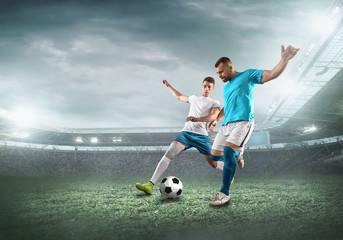 Soccer player on a football field in dynamic action at summer day