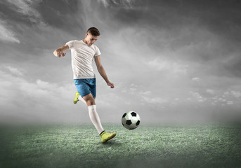 Soccer player on a football field in dynamic action at summer day