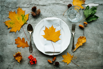 Decorative colorful autumn backgrounds with place mat from red autumn leaves with cutlery, white...
