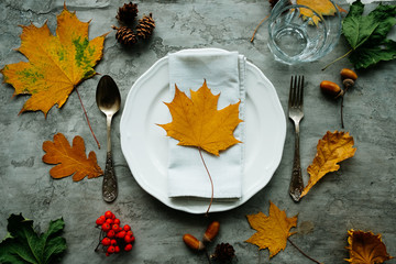 Decorative colorful autumn backgrounds with place mat from red autumn leaves with cutlery, white...