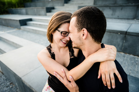 Shy smiling woman embracing her boyfriend