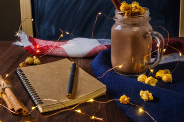 cocoa with popcorn and cinnamon on the table with an open notebook and fountain pen