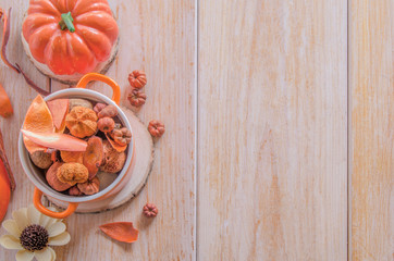 Happy Thanksgiving Day concept. Soup pot with different dry leaves and flowers for autumn festive decoration on wood background.Copy space