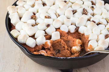 Homemade sweet potato casserole with marshmallows and pecans.