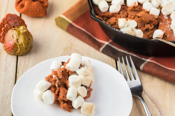 Homemade sweet potato casserole with marshmallows and pecans.