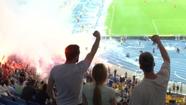 Friends cheering for winning goal, general excitement during football match