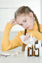 Obraz na płótnie Canvas Portrait of a cute little girl taking medicine at home