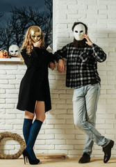 Girl and man in golden mask stay at window