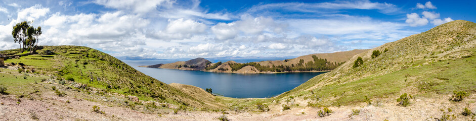Fototapeta na wymiar Panoramic on Isla del Sol with plantations, road, boats and Titikaka Lake on a sunny day