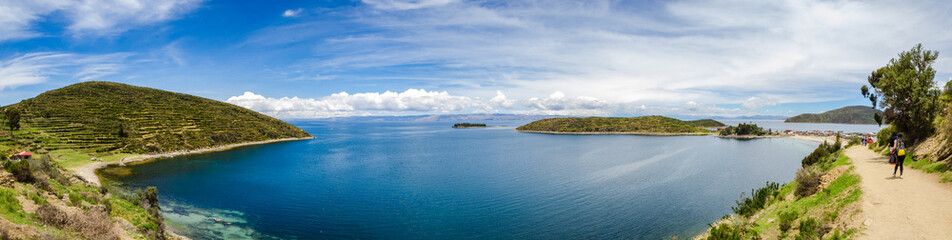 Fototapeta na wymiar Panoramic on Isla del Sol with a blue Titikaka Lake, stones, an island and a few turists on a sunny day