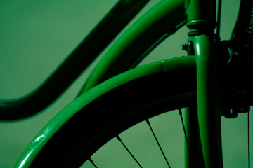 Close up photo of a green bike against a green soft bokeh background