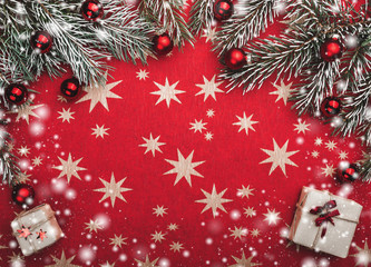 Xmas card, red background with stars. Space for your text. Fir branches with red balls. Top view. Snow effect