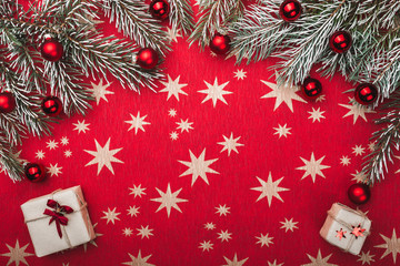 Xmas card, red background with stars. Space for your text. Fir branches with red balls. Top view.