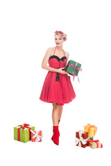 beautiful young pin up woman standing near pile of gift boxes isolated on white