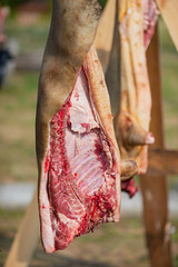Pork carcass close-up hanging on the hook outdoors