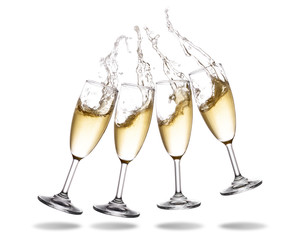 Four champagne cheering with splashing out of glass isolated on white background.