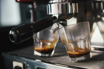 close-up view of professional coffee maker and two glasses with espresso