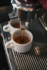 close-up view of coffee maker and two cups with espresso