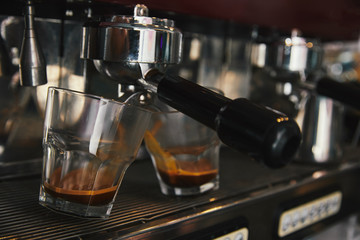 close-up of coffee maker preparing espresso in two cups