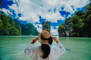 Traveler woman with holding hat joy relaxing looking Beautiful view amazing nature landscape of James Bond island Phuket, Travel adventure Thailand