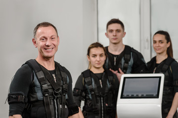 Four happy athletes after EMS training at gym