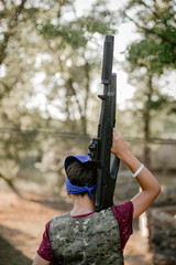 Young boy in uniform holding gun during lasertag