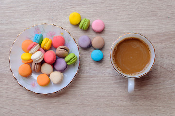 Macaron dessert and coffee on the wooden table.