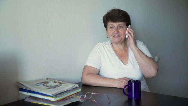 Elder Woman Talking on Cell Phone in the Day in the Kichen
