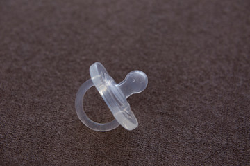 the nipple on a beige background. baby pacifier