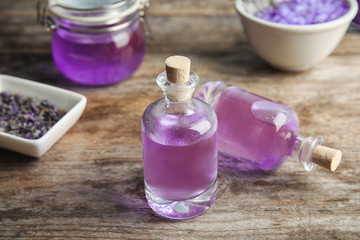 Fototapeta na wymiar Bottles of natural lavender herbal on wooden background