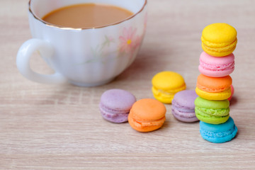 Macaron dessert and coffee on the wooden table.