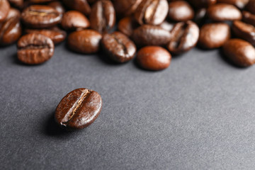 Roasted coffee beans on grey background, closeup
