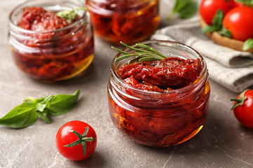 Dried tomatoes in glass jar on table. Healthy snack - obrazy, fototapety, plakaty