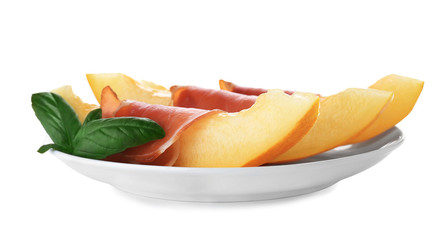 Plate with melon slices and prosciutto on white background