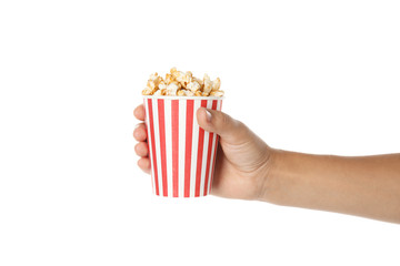 Woman holding cup with delicious popcorn on white background, closeup