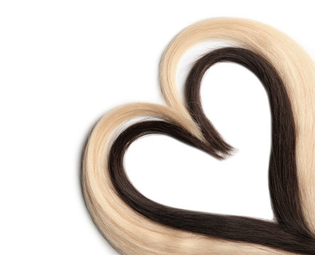 Heart made of blond and brown hair locks on white background