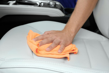 Man washing car seat with rag, closeup