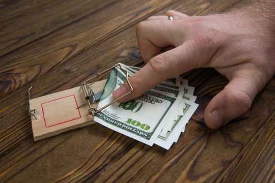 Hand caught in a mousetrap with one hundred dollars banknote. The concept of fraud, bribe, capture of the initiator. business risk. caught stealing