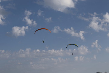 Paragliders into blue sky