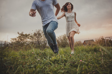 young couple jumping in the field