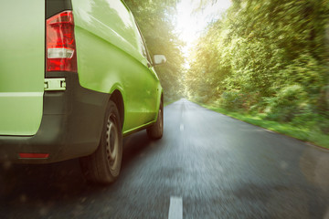 Grüner Transporter fährt durch den Wald