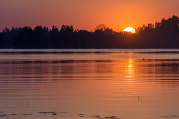 Naklejka premium Sun is going down by the lake