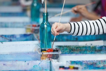 Child's hand with a brush and paints