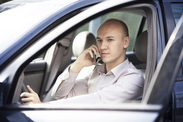 Businessman driving and talking on phone