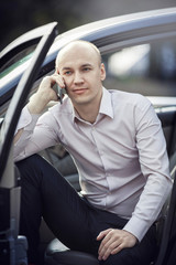 Man using cell phone in car door open