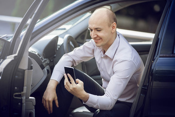 Man using cell phone in car door open