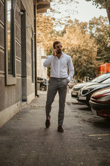 Man walking on the sidewalk and talking on the phone