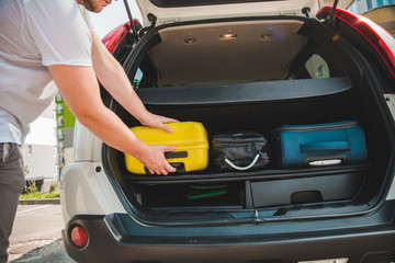Fototapeta na wymiar hands load bags in car trunk